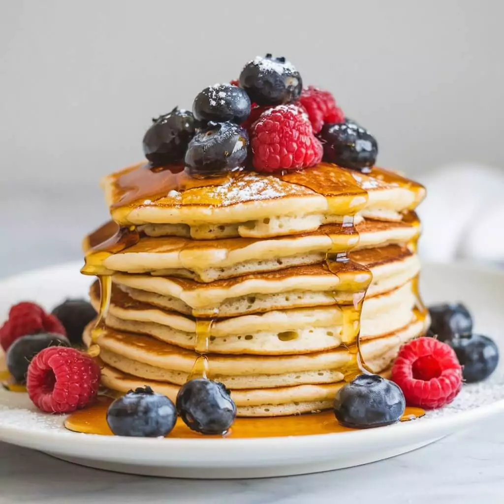 Thermomix best pancake recipe topped with fresh berries and syrup.